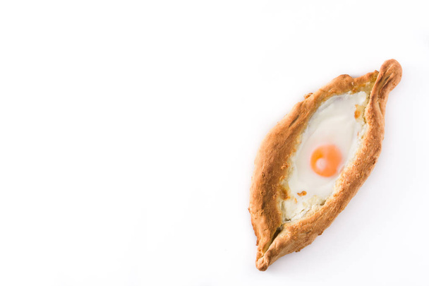 Traditional Adjarian Georgian khachapuri with cheese and egg isolated on white background. Top view. Copyspace - Фото, изображение