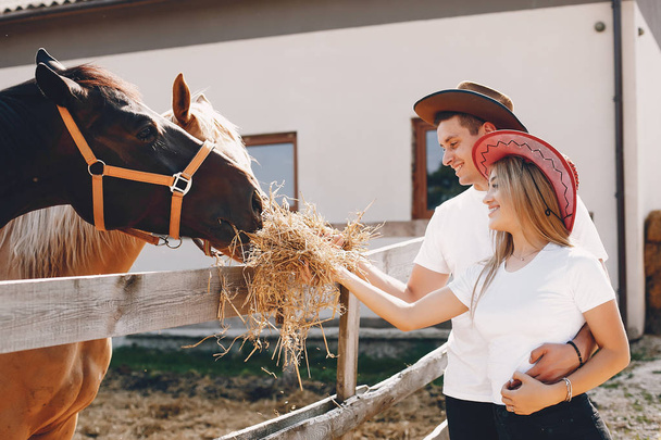 Beautiful couple spend time with a horses - Valokuva, kuva