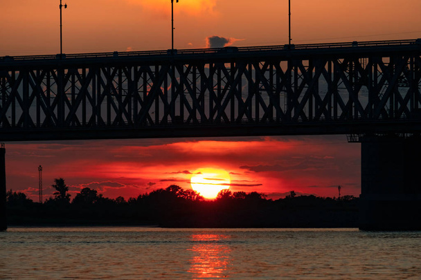 Brücke über den Amur bei Sonnenuntergang. Russland. Chabarowsk. Foto aus der Mitte des Flusses. - Foto, Bild