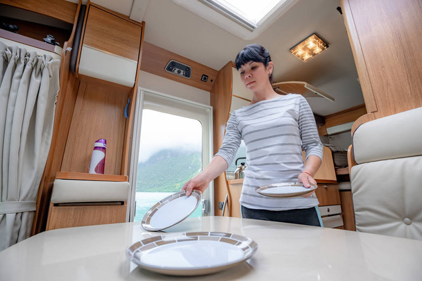 Woman cooking in camper, motorhome interior - Φωτογραφία, εικόνα