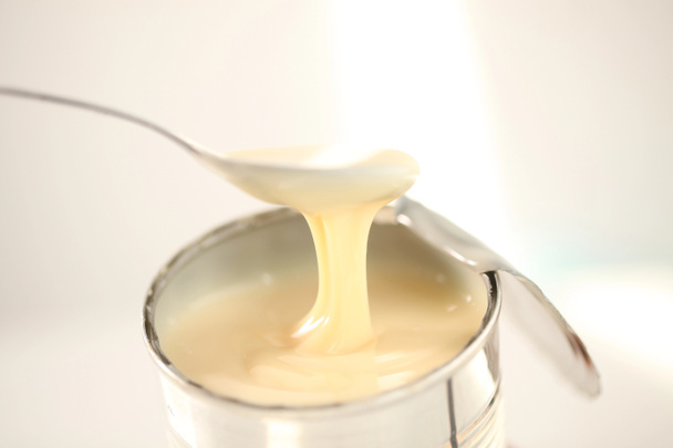 sweetened condensed milk with spoon - Zdjęcie, obraz