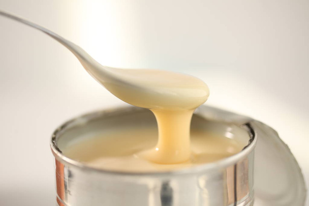 słodzone mleko skondensowane z łyżką - Zdjęcie, obraz