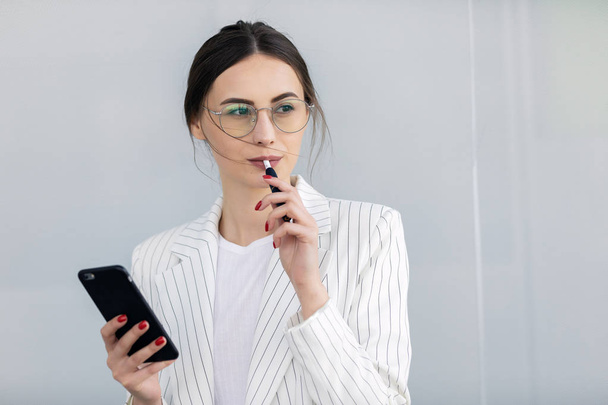 Cropped image of successful business woman wearing suit using modern smartphone - Photo, Image