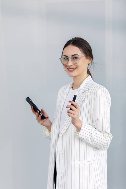 Cropped image of successful business woman wearing suit using modern smartphone - Φωτογραφία, εικόνα