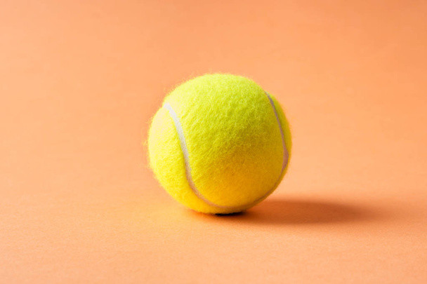 Tennisbal op oranje abstracte achtergrond - Foto, afbeelding