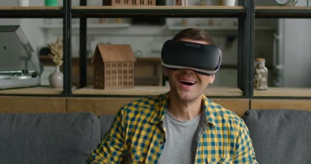 Young man enjoys wearing virtual reality headset - Кадры, видео