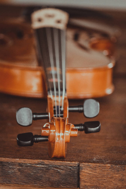 Κοντινό σε ένα βιολί ρηχό βάθος πεδίου στο φόντο του ξύλου - Φωτογραφία, εικόνα