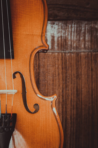 Close up de um violino raso fundo de campo sobre fundo de madeira
 - Foto, Imagem