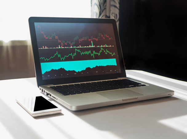 Laptop z wykresu na jego wyświetlanie w miejscu pracy, ekonomista - Zdjęcie, obraz