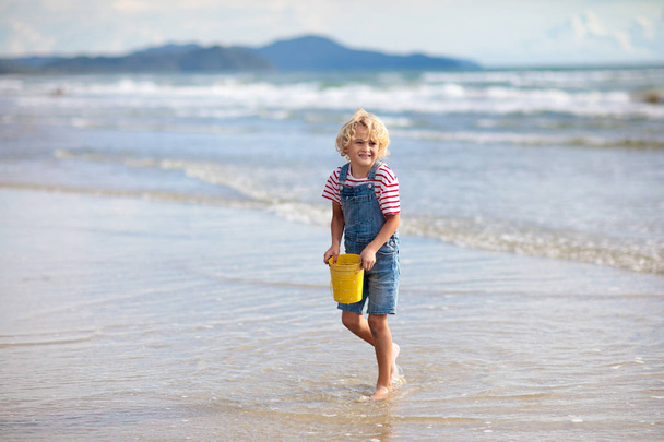 Los niños juegan en la playa tropical. Arena y agua juguete
. - Foto, imagen