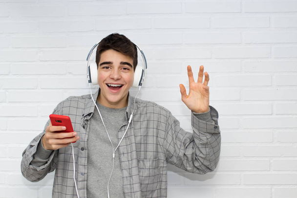 αστείος νέος άντρας με κινητό τηλέφωνο και ακουστικά - Φωτογραφία, εικόνα