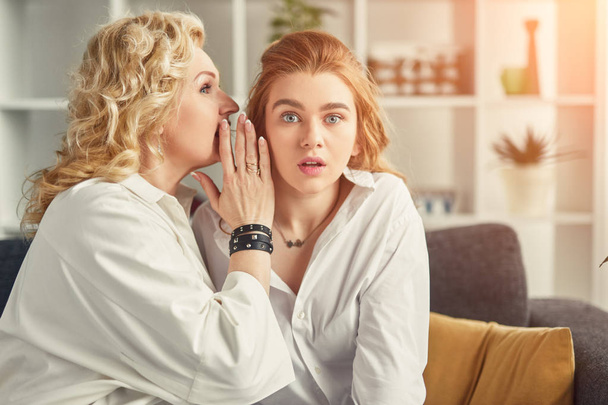 Mother gossiping with shocked daughter - Foto, Bild