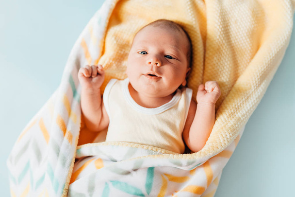 um bebê recém-nascido, um lindo bebê que sorri, em um cobertor quente
 - Foto, Imagem