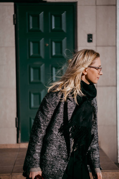 Stylish blonde walks in front of modern building - Fotó, kép
