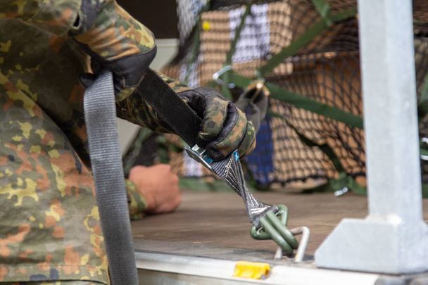 Saksan armeijan sotilas sitoi lastin köydellä
 - Valokuva, kuva