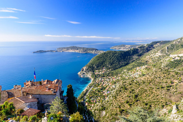 Eze town, France - March 9, 2018: Scenic view of the Mediterranean coastline and medieval houses from the top of the town of Eze village on the French Riviera - Fotó, kép
