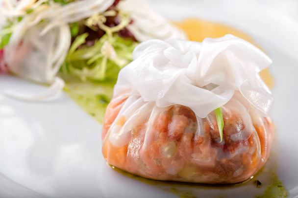 steamed stuffed dim sum from rice dough close-up and fresh salad on white plate   - 写真・画像