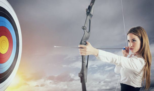 Donna d'affari con arco e freccia che punta al centro del bersaglio
. - Foto, immagini