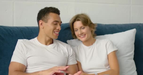 Young mixed couple relaxing in bed in the morning - Video
