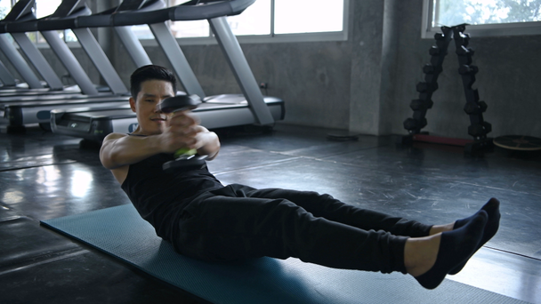 Sports concept. The young man is exercising his stomach in the fitness. - Video, Çekim