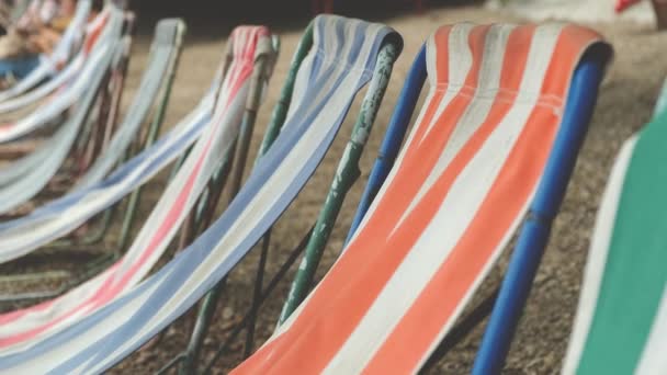 Deck chairs are blown by the wind on a pebble beach, slow to 4k - Footage, Video