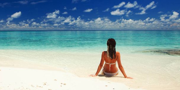 Νεαρή γυναίκα της μόδας χαλαρώστε στην παραλία. Ευτυχισμένος τρόπος ζωής. Λευκή άμμος, μπλε ουρανός και κρυστάλλινη θάλασσα της τροπικής παραλίας. Διακοπές στον Παράδεισο. Θαλάσσια παραλία χαλαρώστε, ταξιδέψτε στα νησιά - Φωτογραφία, εικόνα