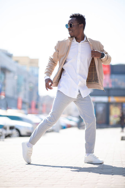 schöner schwarzer junger Mann in Jacke und weißem Hemd auf der Straße - Foto, Bild