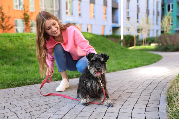 Jovem com cão Schnauzer em miniatura ao ar livre
 - Foto, Imagem