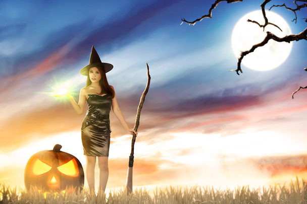 Asian witch woman with magic shine on her hand and broom - Фото, изображение