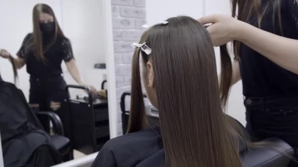 Menina bonito com cabelos longos morena cabeleireiro fazendo laminação de cabelo em um salão de beleza. conceito de tratamento de cabelo
  - Filmagem, Vídeo