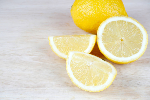 sour yellow lemon slices on white table surface - Photo, image
