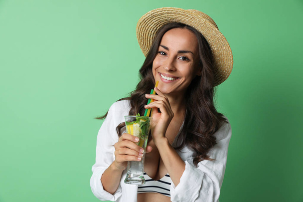 Young woman with refreshing drink on green background - Фото, изображение