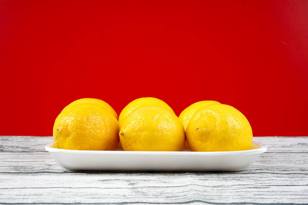 whole yellow lemons on plate - Photo, image