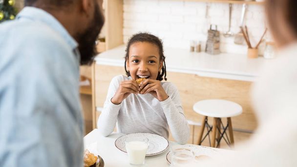 Nettes Afro-Mädchen bevorzugt Kekse statt Milch zum Frühstück - Foto, Bild