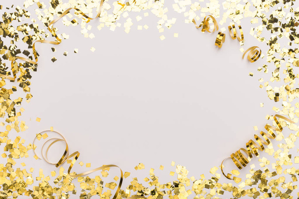 Sparkling frame of gold confetti on white for advertisement - Photo, Image