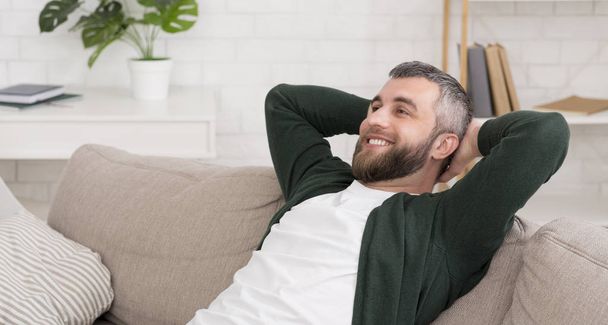 Bell'uomo caucasico che si rilassa sul divano a casa
 - Foto, immagini