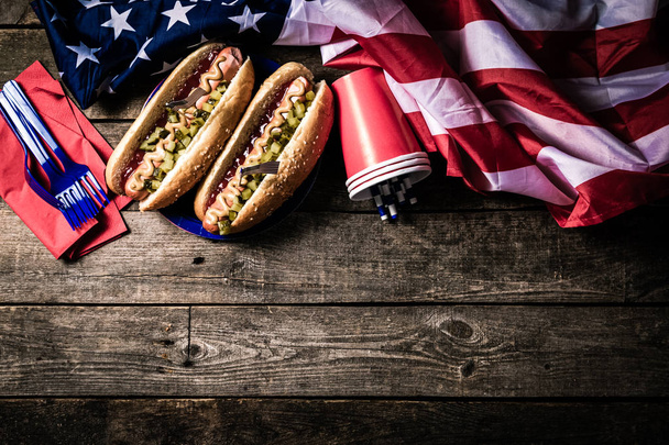 Εθνική αργία των ΗΠΑ Ημέρα της Εργασίας, Ημέρα Μνήμης, Ημέρα της Σημαίας, 4 Ιουλίου - χοτ ντογκ με κέτσαπ και μουστάρδα σε φόντο ξύλου - Φωτογραφία, εικόνα