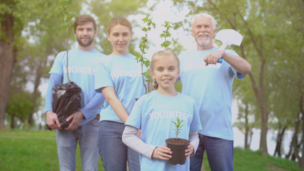 Group of volunteers holding trees saplings and shovel, nature conservation - Footage, Video