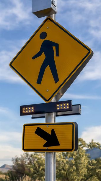 Marco vertical letrero de cruce peatonal y flecha diagonal letrero derecho con luces intermitentes
 - Foto, imagen
