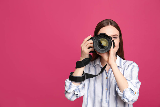 Professional photographer taking picture on pink background - Valokuva, kuva