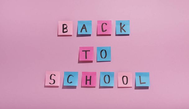 Back to school text of colored stickers on pink background - Zdjęcie, obraz