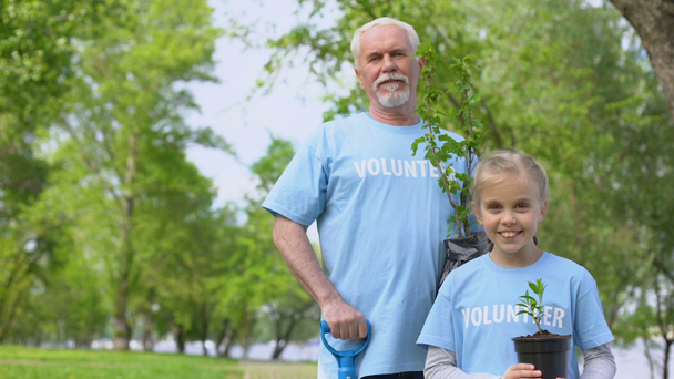 Feliz hombre maduro y nieta sosteniendo planta verde arbolito, eco voluntariado
 - Metraje, vídeo