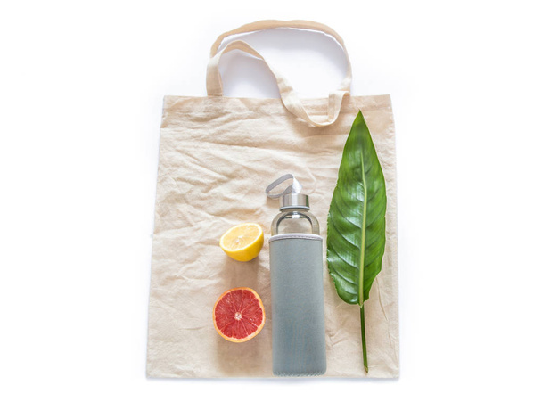 Cotton bag with water bottle fruits raw lemons green leaf on whi - Photo, Image