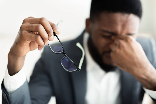 Tired african businessman taking his glasses off - Foto, Bild