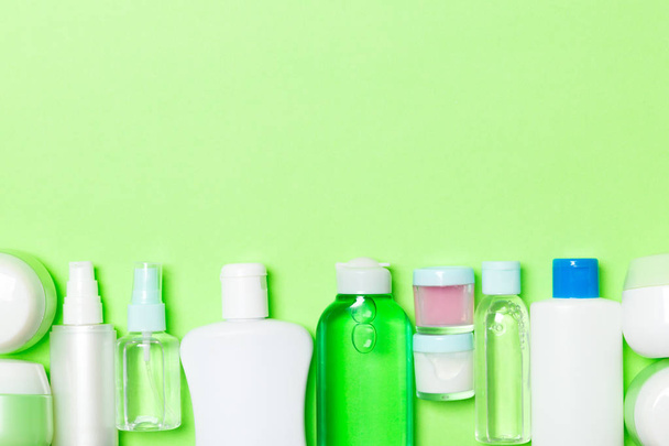 Composição de leigos plana com cosméticos e garrafas de creme no fundo verde. Conceito de produtos de beleza com espaço de cópia
 - Foto, Imagem