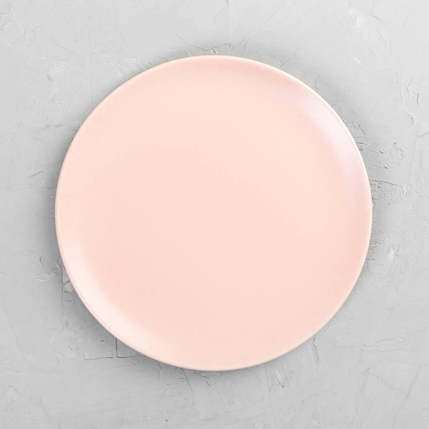Порожня рожева або коралова кругла тарілка на дерев'яному фоні столу. Вид зверху, шаблон вашого дизайну
 - Фото, зображення