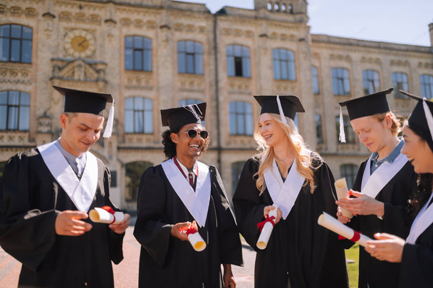 Fröhliche Abschlussschüler freuen sich über ihre Diplome. - Foto, Bild