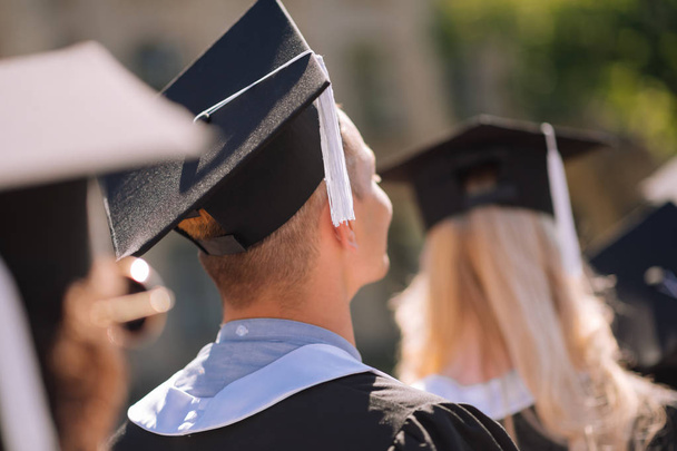Young graduates wearing masters capes receiving diplomas. - Photo, Image