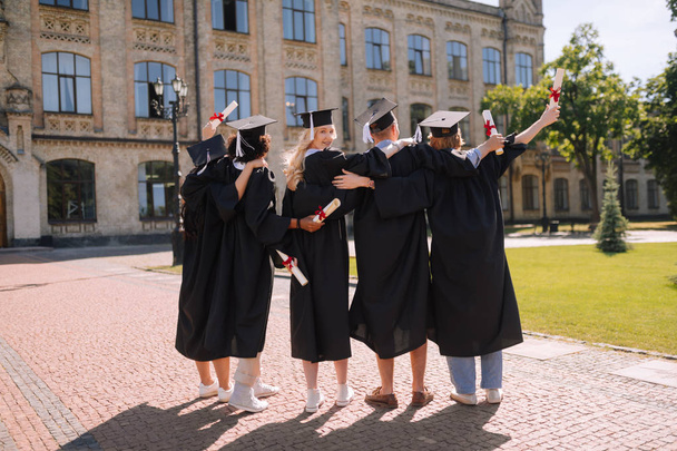 Graduates standing next to each other in front of university. - Fotoğraf, Görsel