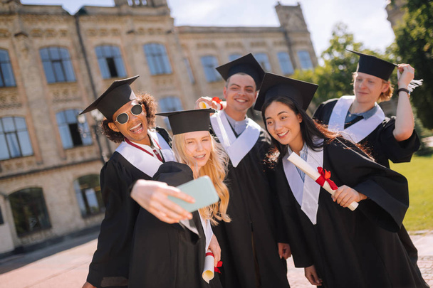 Allegro gruppi compagni di prendere selfie dopo la loro laurea
. - Foto, immagini